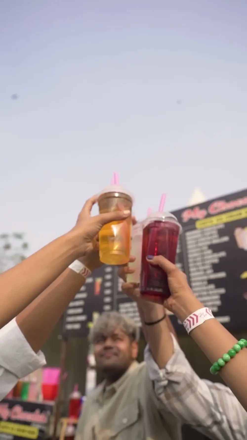 Hands raising drinks in a toast