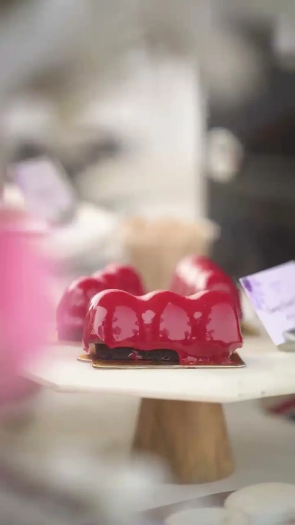 A glossy red dessert on a white stand