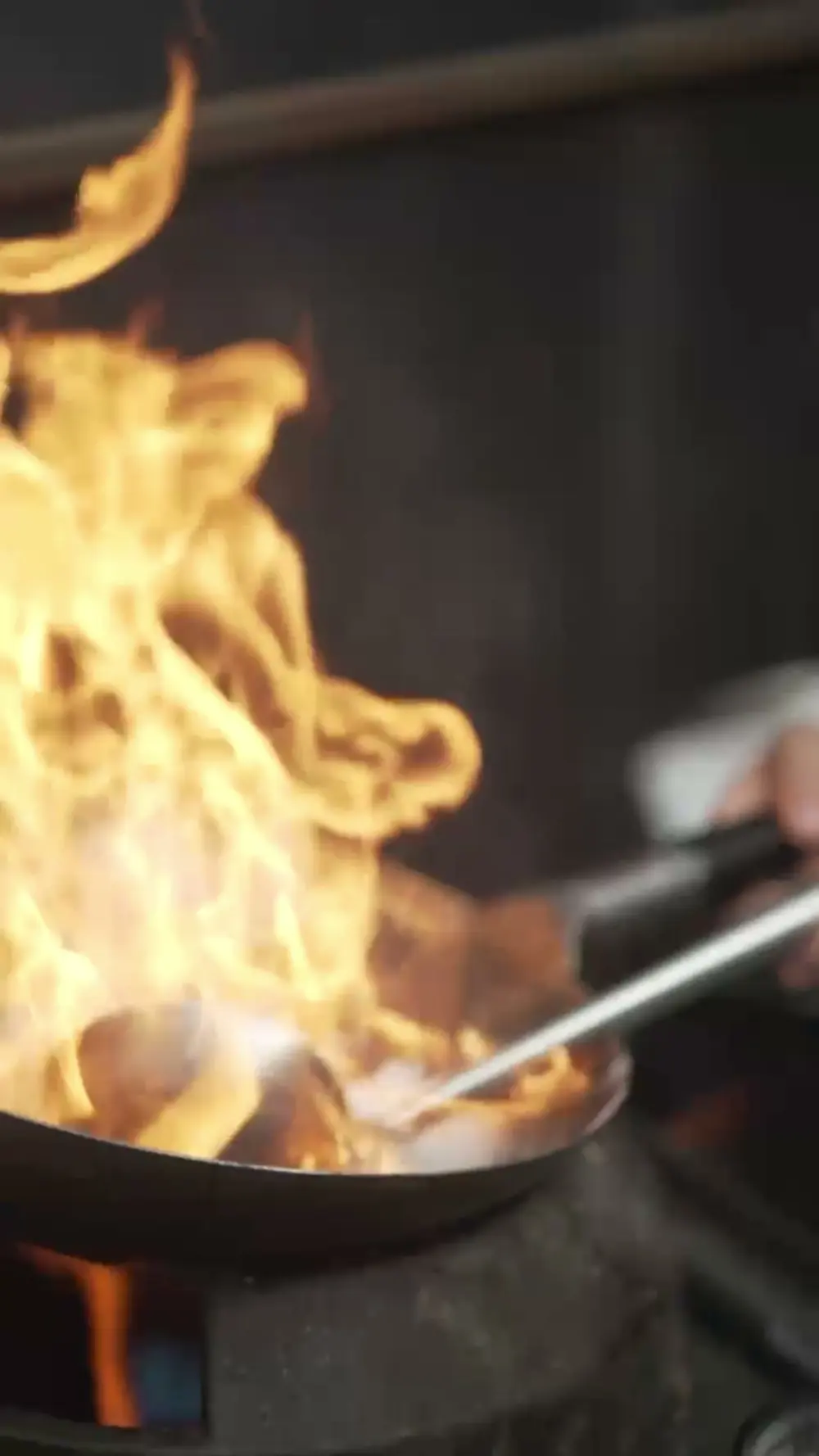Flames rising from a wok at a food stall