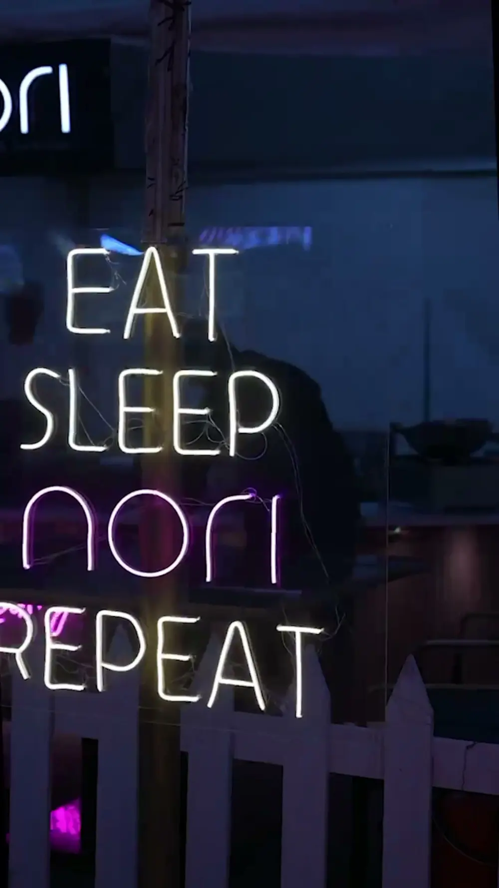A neon sign reading Eat Sleep Nori Repeat