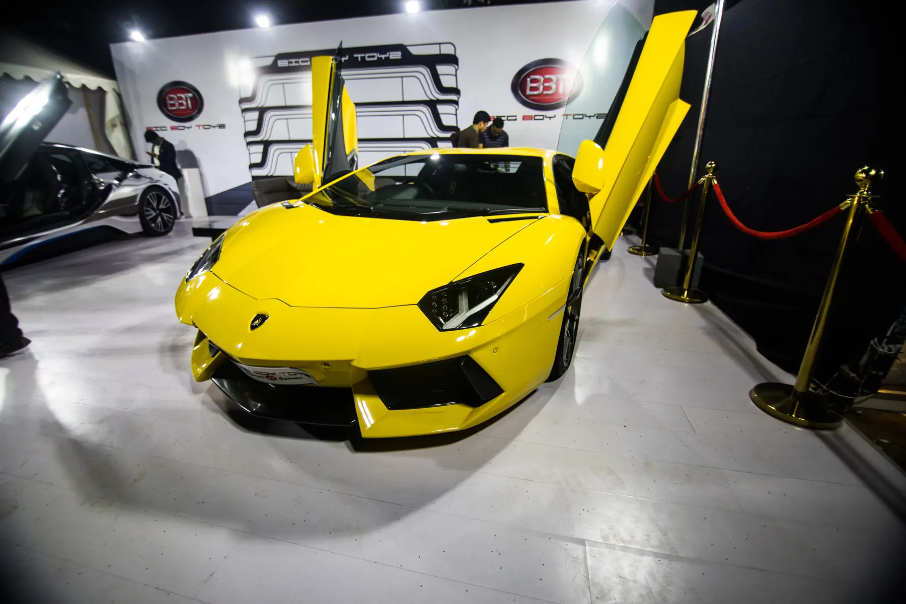 A yellow supercar with scissor doors on display