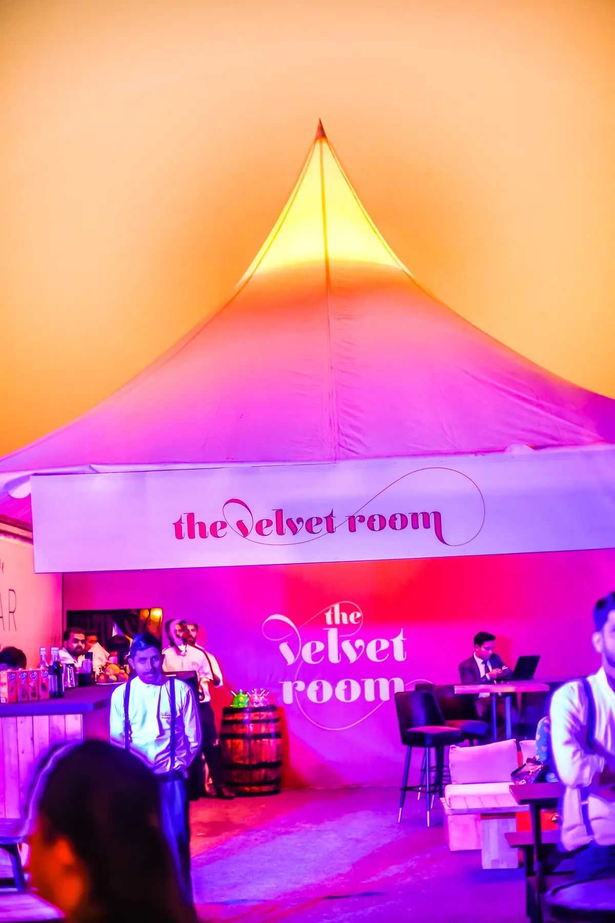 The Velvet Room bar under a glowing pink canopy