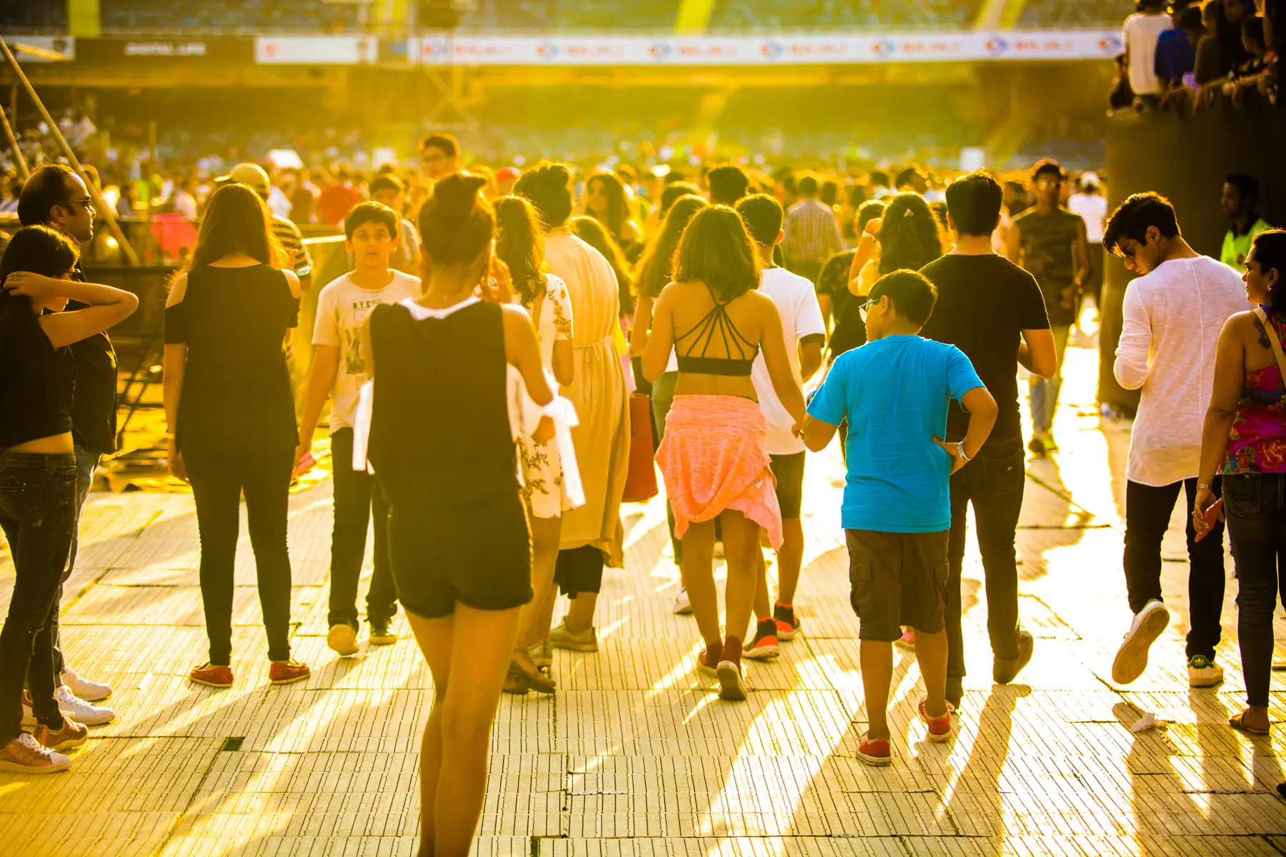 Guests walking into the stadium ground in the evening sun